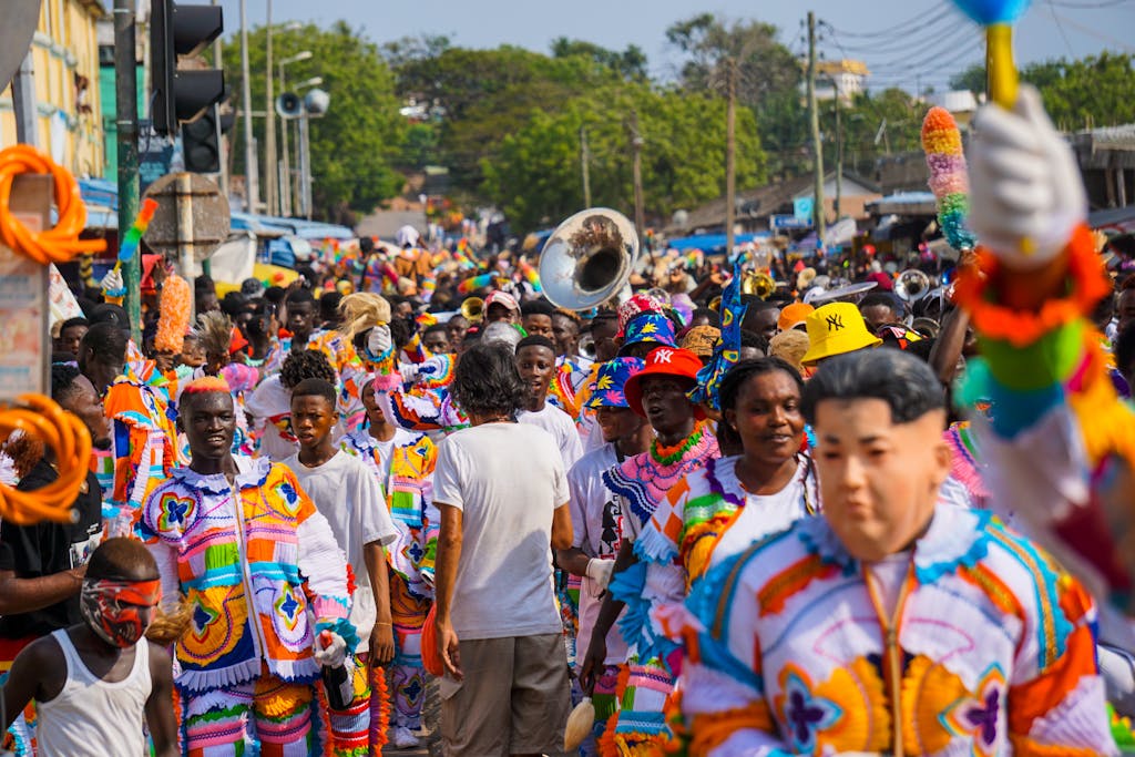 A lively street parade featuring people in colorful costumes, celebrating cultural festivities.