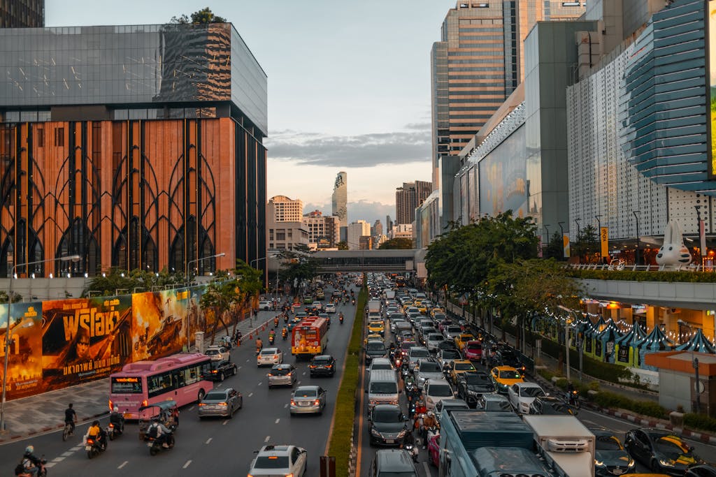 Vibrant cityscape of Bangkok at dusk with bustling traffic and skyline in view.