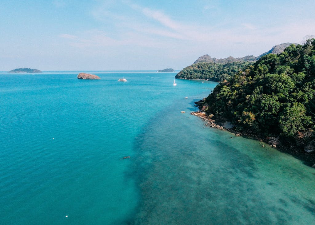 A stunning aerial view of the turquoise waters and lush greenery on the coast of Kedah, Malaysia.