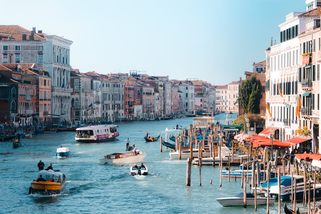 Experience the vibrant life along Venice's Grand Canal, featuring iconic boats and historic architecture.
