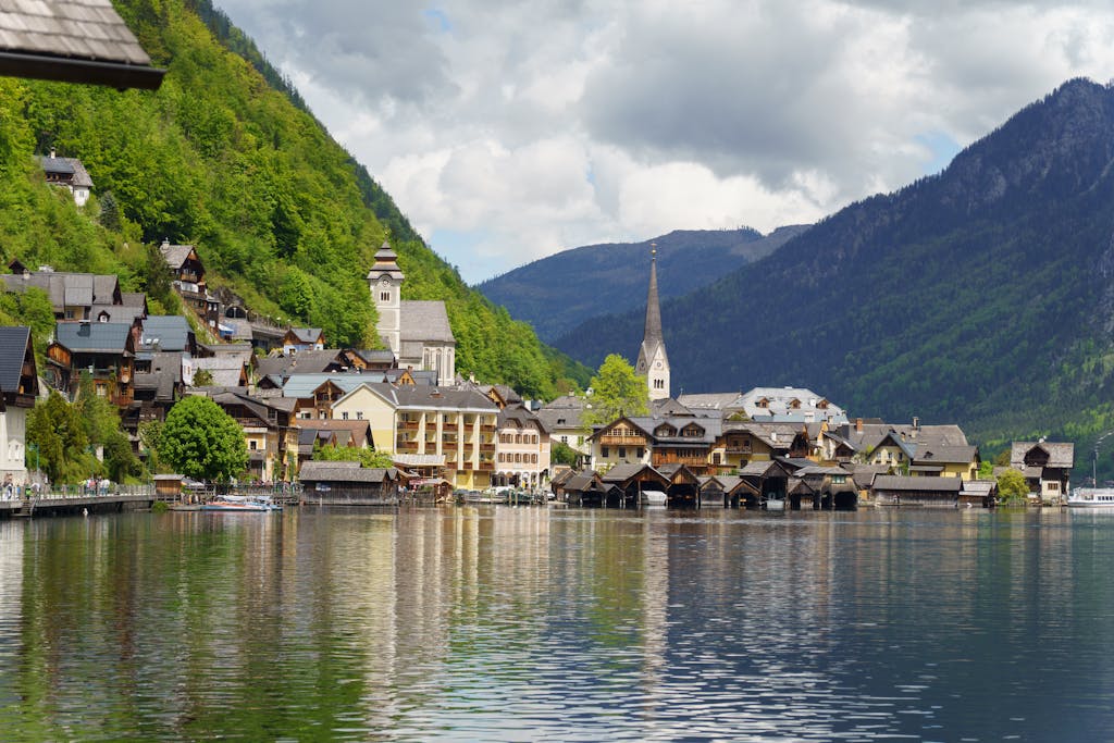 Picturesque view of Hallstatt village in Austria with mountain backdrop and lake reflections.